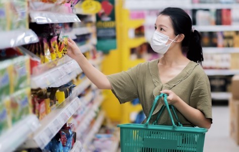 Woman wears a mask while grocery shopping.