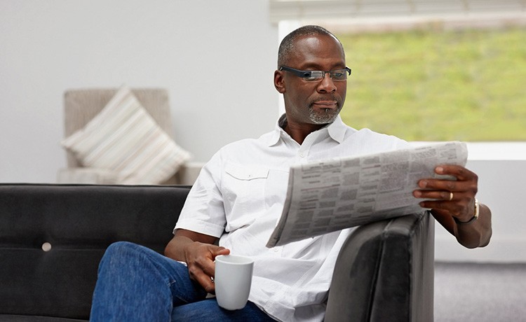 African American man reads newspaper