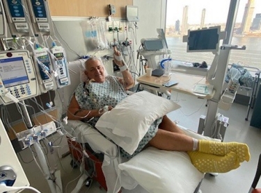 Pat M. recovers in a hospital bed after his successful heart transplant.