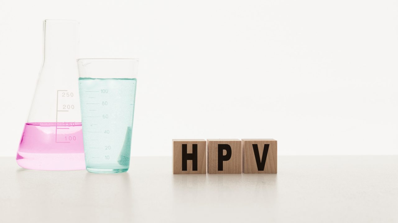 HPV Human Papillomavirus acronym on wooden cubes. HPV on cubes on a white background with chemical reagents,