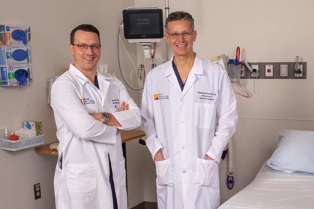 Hernia center doctors in white lab coats stand in a surgical recovery room.