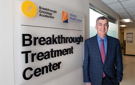 Dr. Eric Whitman poses beside the sign for the Breakthrough Treatment Center