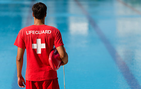 life guard keeps swimmers safe in the water of a pool.
