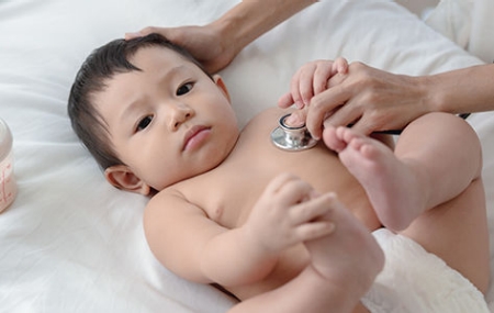 A doctor listens to the lungs of a baby with RSV.