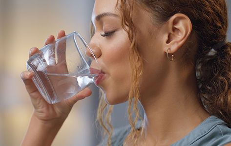 women drinking a glass of water