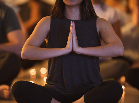 A woman sits in lotus pose.