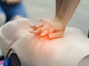 Hands Of A trainee doing chest compression during defibrillator CPR Training.