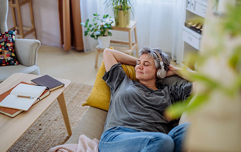woman laying down with  headphones on