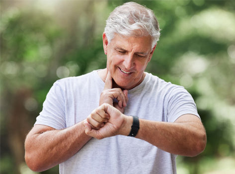A middle-aged man checks his pulse correctly while exercising.