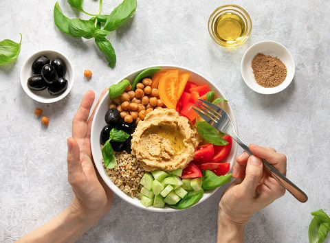 Heart healthy vegetarian bowl with hummus, olives and quinoa.