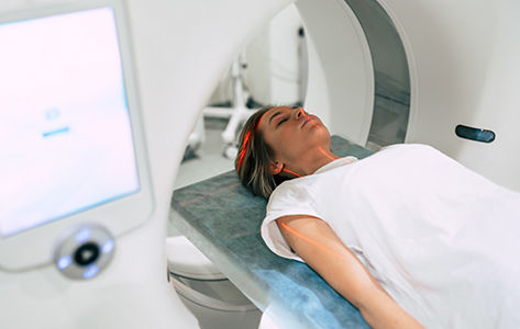 A young woman moves through a PSMA Pet scan machine.