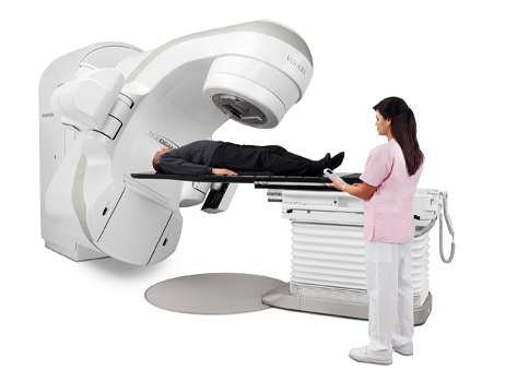 TrueBeam® Radiotherapy System with therapist standing next to it.