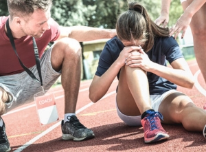 female athlete holding knee in pain