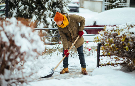 Man practicing winter safety while shoveling snow
