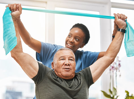 Physical Therapist helping a patient stretch a band