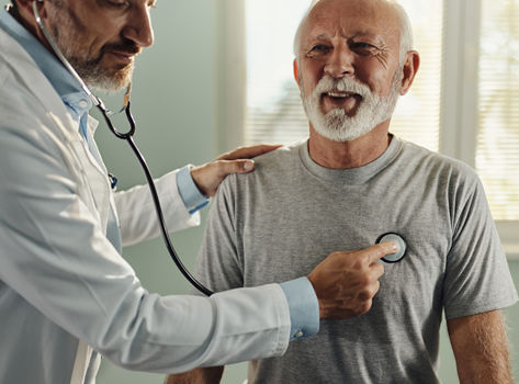 Doctor listening to a man's heartbeat with a stethoscope