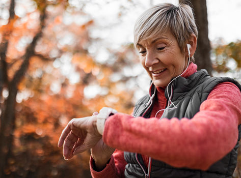 Woman outdoors checking her heart rate on her smart watch