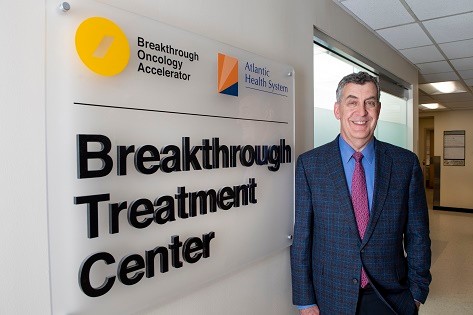 Dr. Eric Whitman stands in front of Breakthrough Treatment Center sign.