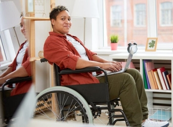 Una mujer en silla de ruedas lee un boletín informativo de salud mental en línea.