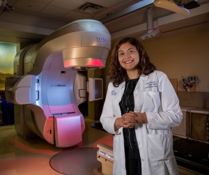 A physician standing with a cardiac-sparing radiation therapy machine.