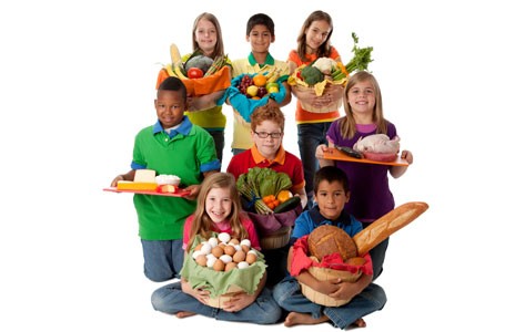 Grupo de niños sosteniendo comida sana.