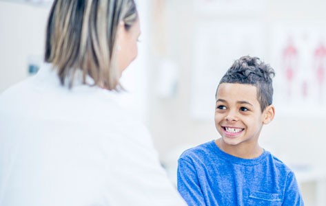 Una neuróloga pediatra visita a un niño con tumor cerebral