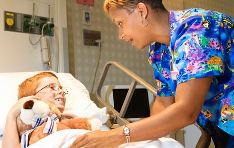 Una enfermera brinda cuidados paliativos a un niño enfermo