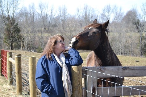 Shannon visita un caballo en su prado.
