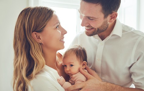 Smiling parents holding newborn