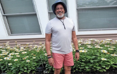 Jim T. sonríe fuera de su casa después de un trasplante de corazón.