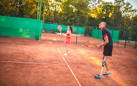 Una persona amputada jugando al tenis