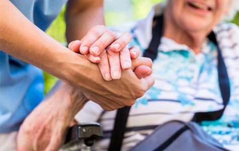 Sosteniendo la mano de una paciente de cuidados paliativos