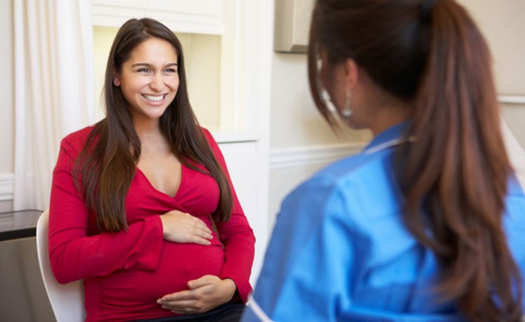 Una mujer embarazada se reúne con una especialista materno-fetal