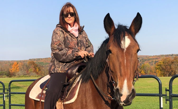 Jill se sienta en un caballo de su granja tras recuperarse de una cirugía de columna vertebral.