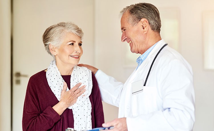 Doctor with patient placing hand on shoulder in comfort