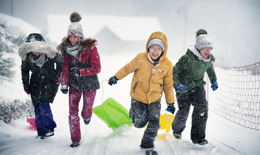 Children holding sleds in the snow