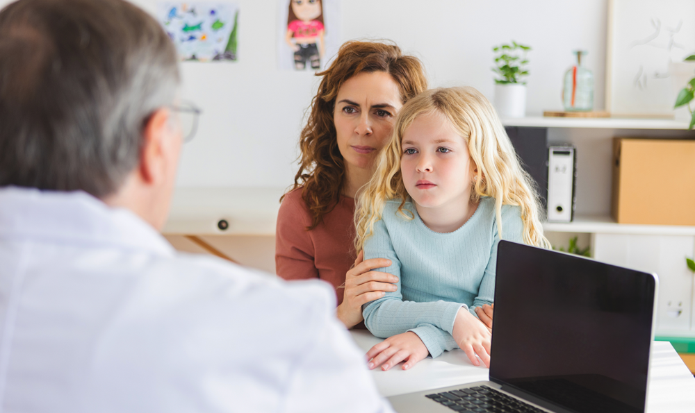 A woman and child speaking with a pediatrician