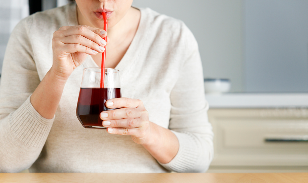 A woman drinking cranberry juice.