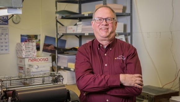 Tom posing at his job.