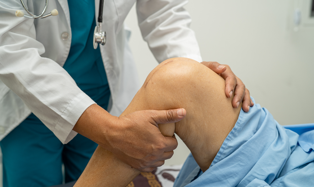 A doctor checking on a patient's knee.