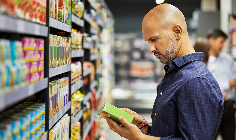 A man examining the nutrition facts on a food box