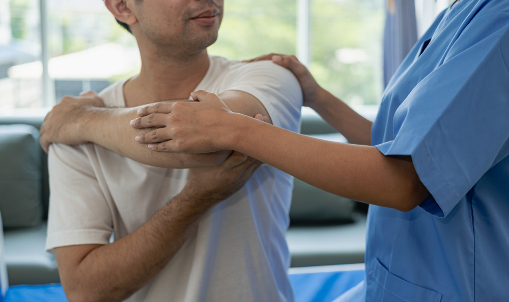 Doctor helping a patient with their shoulder.