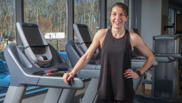Adrianne posing on a treadmill.