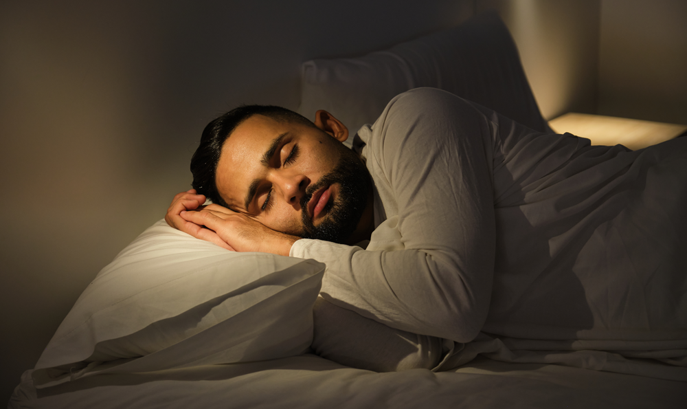 A man putting sleeping in bed.