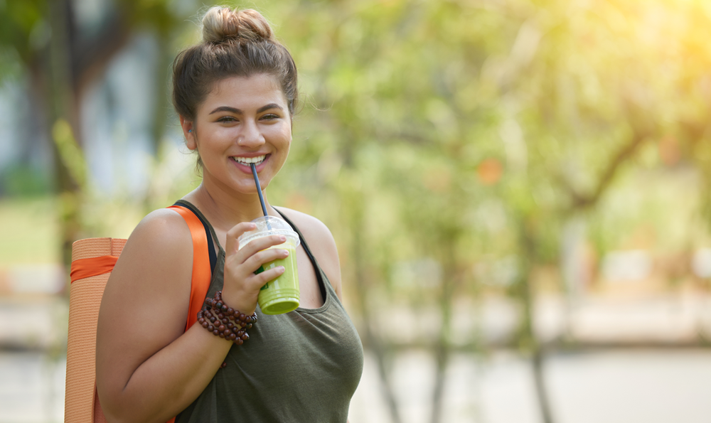 A woman drinking a green drink