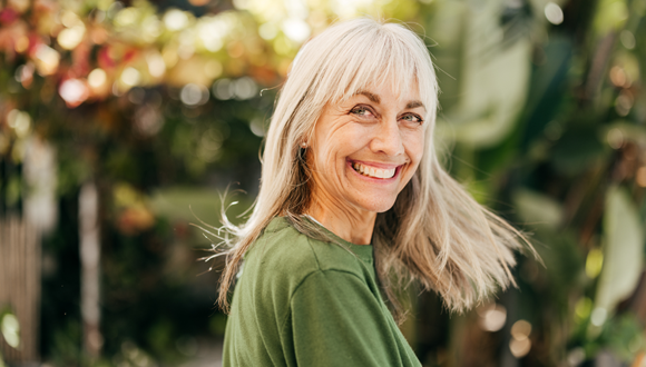 Woman smiling in front of scenery. 