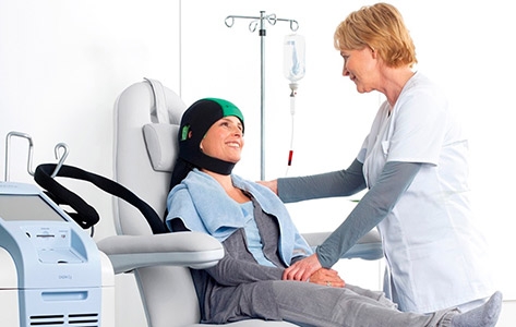 Woman receiving scalp cooling services to preserve hair during chemotherapy.
