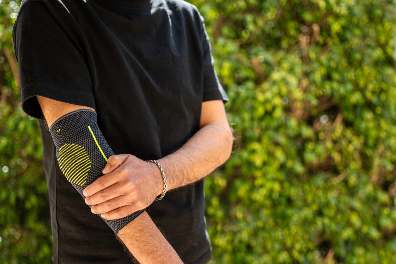 Man has his elbow wrapped in a supportive brace.